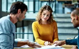 Adversity Intelligence: Building Resilience for Business Professionals 5 Coworkers reviewing project documents together at a table