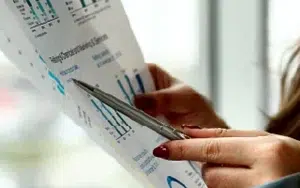 Budgeting and Financial Management Essentials for Business Leaders 16 Business leader reviewing financial charts and budget figures with a pen
