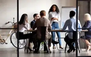 Business Communication Series: Core Workplace Skills 23 Team listening as a leader speaks during an office meeting
