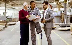 Career Development Fundamentals: How to Build Professional Expertise 27 Three colleagues reviewing documents on a workshop floor