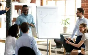 Critical Thinking Fundamentals: Build Stronger Analytical Abilities 38 Facilitator presenting at a flip chart to engaged colleagues