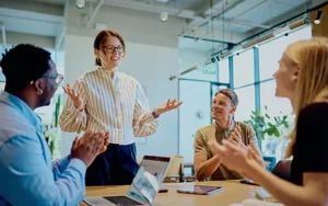 Team applauding a smiling leader during an engaging workplace meeting