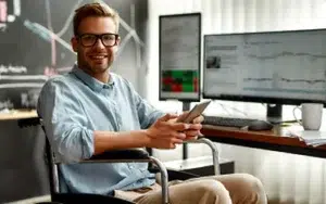 Microsoft Office Excel Advanced: Master Macros and Automation 16 Smiling professional in a wheelchair holding a phone beside data monitors