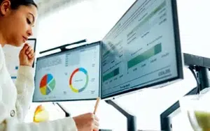 Project Portfolio Management Essentials for Leaders & PMs 23 Professional analyzing charts on dual monitors
