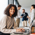 Emotional Intelligence (EIQ-2) Assessment Image of Woman Smiling with Peers in the Back
