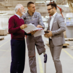 Portrait of three men standing and discussing in a furniture factory - Career Development