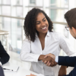 Multiracial businessman businesswoman shake hands starting collaboration at group negotiations, positive people gathered at modern office boardroom, partnership teamwork and business etiquette concept - Delegating for Results - retaining top performers - Transitioning from Peer to Boss