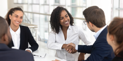 Multiracial businessman businesswoman shake hands starting collaboration at group negotiations, positive people gathered at modern office boardroom, partnership teamwork and business etiquette concept - Delegating for Results - retaining top performers - Transitioning from Peer to Boss