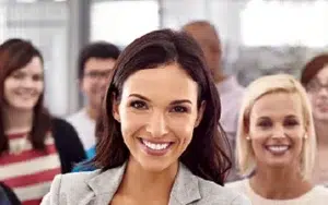 Creating Individual Development Plans for Employee Growth 34 Smiling professional standing in front of colleagues, ready to grow her career