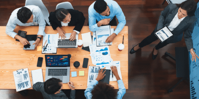 A bird's-eye view of a team presenting a data-driven business project at work.