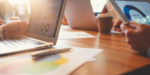 A group of business professionals meeting at a table reviewing data analytic information and graphs.