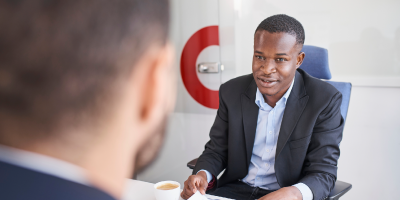 Supervisor at his desk in a modern office, engaged in a challenging conversation with an employee.