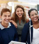 A group of young people smiling in the workplace as they go to training.