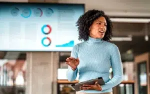 AI for Business: Essentials for Practical Applications 7 Executive presenting confidently in front of a data display