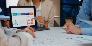 Business professionals gathered around a table discussing performance management in a workplace setting.