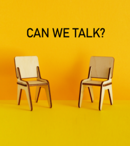 Two chairs against a bright yellow background with the text 'Can We Talk?' symbolizing serious workplace conversations.