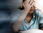 Overwhelmed female office worker showing stress at workplace