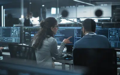 Two professionals collaborating at computers.