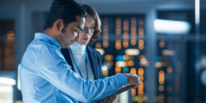 Two people discussing data on tablet