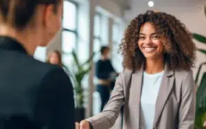 Workplace Professionalism Skills for Career Success 38 African American professional woman shaking hands with a new colleague in a workplace setting.