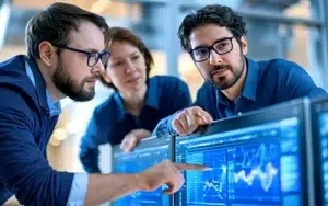 Advanced SQL Querying for Data Analysts & Database Professionals 1 Data analysts pointing at query results and charts on computer monitors