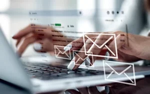 Business Writing Essentials: Write with Clarity and Impact 26 Hands typing a message on a laptop with email icons floating above