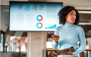 Super Intelligence Essentials for Federal Workplace Applications 39 Executive presenting confidently in front of a data display